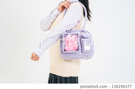 一名女學生背著裝有絨毛玩具的書包 一名女學生背著裝有絨毛玩具的書包 136290377