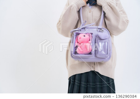 一名女學生背著裝有絨毛玩具的書包 136290384