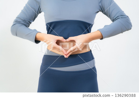 A woman making a heart symbol on her stomach A woman making a heart symbol on her stomach 136290388