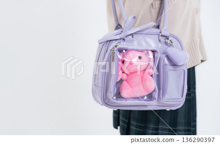 A female student carrying a bag containing a stuffed toy A female student carrying a bag containing a stuffed toy 136290397