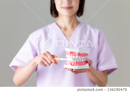 一位身穿醫用工作服的中年女牙醫 一位身穿醫用工作服的中年女牙醫 136290478