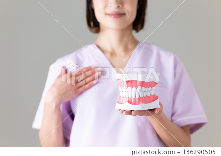 A middle-aged female dentist wearing a medical scrub 136290505