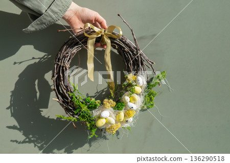 Unrecognizable woman holding Candid Easter wreath arrangement decor. Handmade craft creative present or gift idea. Zero waste eco-friendly springtime holiday 136290518