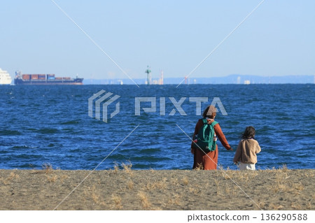 父母與孩子一起觀賞冬日的大海 父母與孩子一起觀賞冬日的大海 136290588
