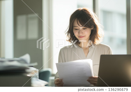 /* 日本女商務人士在辦公室工作，正在查看文件的場景 */ 136290879