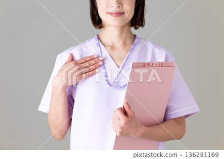 A middle-aged female nurse in a medical scrub 136291169