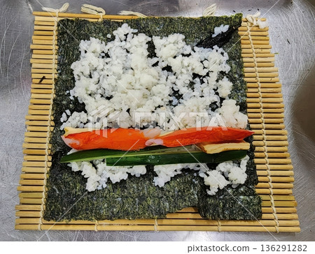 Making Homemade Sushi Roll with Crab, Cucumber and Tamago on Bamboo Mat Making Homemade Sushi Roll with Crab, Cucumber and Tamago on Bamboo Mat 136291282