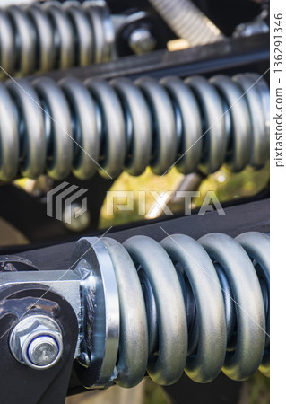 Steel silver spring as part of black heavy agricultural, industrial machine. Technology 136291346