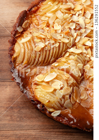 Fresh pear tart with almond slices on a wooden table Fresh pear tart with almond slices on a wooden table 136291552