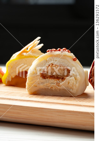 Colorful dessert rolls on a wooden board at a street food market in the evening Colorful dessert rolls on a wooden board at a street food market in the evening 136291572