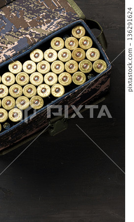 Container holds many rounds of ammunition on a black surface in a simple setting Container holds many rounds of ammunition on a black surface in a simple setting 136291624