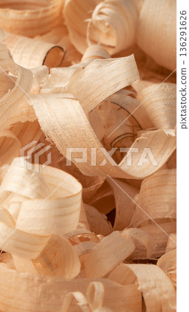 Wood shavings scattered on a workbench in a workshop during daytime activities Wood shavings scattered on a workbench in a workshop during daytime activities 136291626