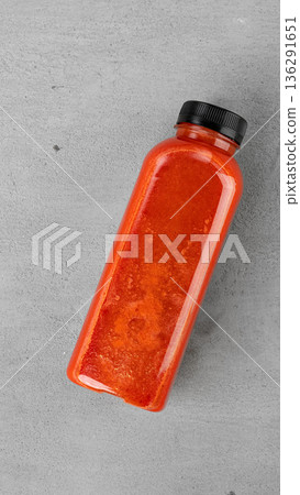 Bottle filled with orange drink placed on a grey surface in a kitchen setting Bottle filled with orange drink placed on a grey surface in a kitchen setting 136291651