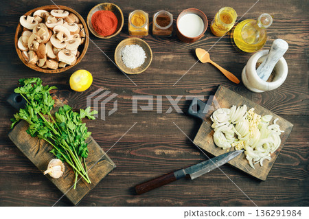 Top view of sliced onion, garlic, and mushroom with fresh herb on rustic wood table 136291984