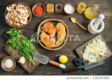 Chicken preparation with fresh ingredients on wooden kitchen table before cooking 136291988
