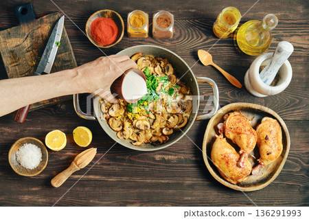 Pouring heavy cream to a pot filled with fried onion and mushrooms 136291993