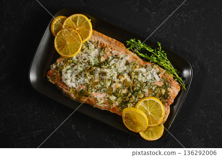 Pink salmon dish with herbs and lemon on a black plate for a tasty meal idea 136292006