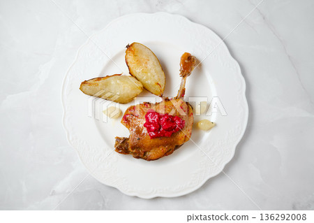 Enjoying duck confit served with roasted potatoes and sauce in a simple dining setup Enjoying duck confit served with roasted potatoes and sauce in a simple dining setup 136292008