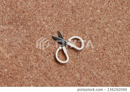 Small scissors placed on a cork background Minimalist stock photo of everyday items Small scissors placed on a cork background Minimalist stock photo of everyday items 136292098