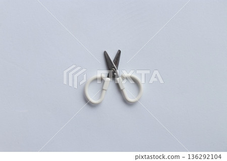 Small scissors placed on a white background Minimalist stock photo of everyday items 136292104