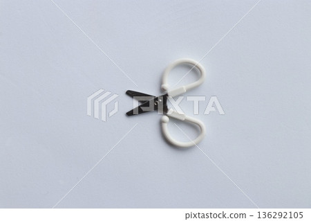Small scissors placed on a white background Minimalist stock photo of everyday items 136292105