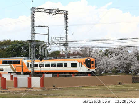 A Kintetsu express train runs on the Kintetsu Nara Line with cherry blossoms in full bloom at the Nara Heijo Palace ruins. A Kintetsu express train runs on the Kintetsu Nara Line with cherry blossoms in full bloom at the Nara Heijo Palace ruins. 136293566
