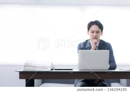 一幅畫面描繪了一位總裁或經理正憂心忡忡地看著一張業務策略和業績圖表,他手托著下巴,顯得猶豫不決。 一幅畫面描繪了一位總裁或經理正憂心忡忡地看著一張業務策略和業績圖表,他手托著下巴,顯得猶豫不決。 136294295