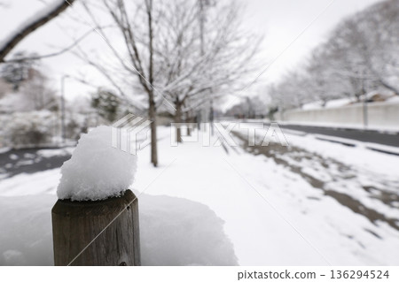 Snow piled up on a wooden fence 136294524