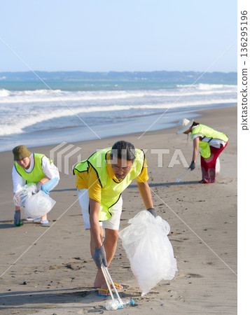 Volunteer staff picking up trash on the beach Environmental protection activities Volunteer staff picking up trash on the beach Environmental protection activities 136295196