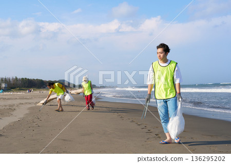 Young volunteers and their friends working on beach cleanup activities 136295202