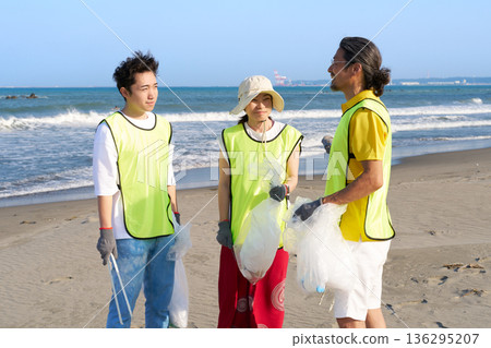 在環保志工活動中，男女工作人員面帶微笑，邊走邊聊。 136295207