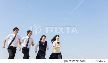 Four high school students, both boys and girls, run with smiles under the blue sky. This refreshing advertising material evokes images of youth, hope, the future, and education. Four high school students, both boys and girls, run with smiles under the blue sky. This refreshing advertising material evokes images of youth, hope, the future, and education. 136295677