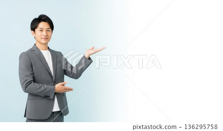 A smiling male business person in a suit giving directions. A versatile advertising image with ample white space on the right. A smiling male business person in a suit giving directions. A versatile advertising image with ample white space on the right. 136295758