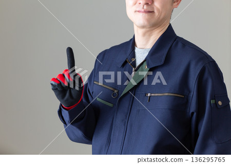 A middle-aged male businessman in work clothes pointing his index finger 136295765
