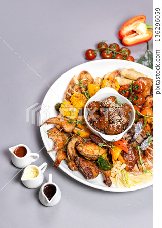 Close-up of chicken platter with vegetables and sauce on white plate Close-up of chicken platter with vegetables and sauce on white plate 136296059