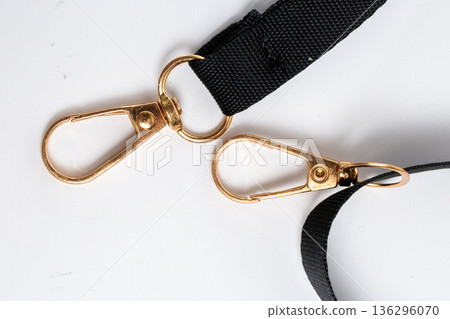 Close-up of two gold-tone carabiners with rings on black nylon strap Close-up of two gold-tone carabiners with rings on black nylon strap 136296070