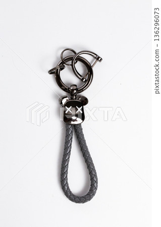 Close up of black metallic bear keychain with braided leather loop isolated on white background Close up of black metallic bear keychain with braided leather loop isolated on white background 136296073