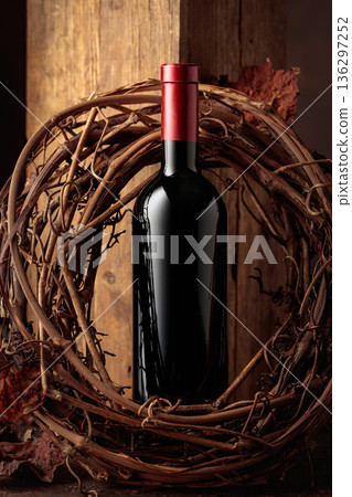 Bottle of red wine and dried grapevine wreath. 136297252
