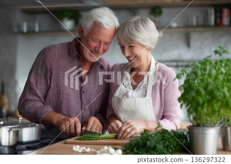 Senior couple chopping herbs in kitchen Senior couple chopping herbs in kitchen 136297322