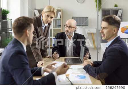 Colleagues in office meeting review data charts for strategy planning and goals Colleagues in office meeting review data charts for strategy planning and goals 136297698
