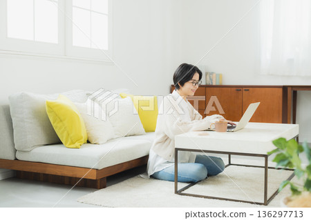 A woman watching a computer at home 136297713