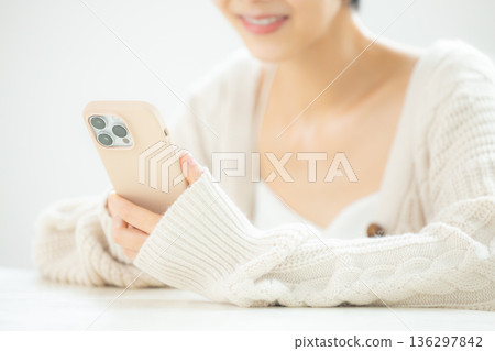 A woman watching a smartphone A woman watching a smartphone 136297842