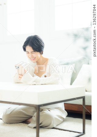 A woman watching a smartphone A woman watching a smartphone 136297844