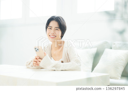 A woman watching a smartphone A woman watching a smartphone 136297845
