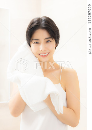 A woman wiping his face with a towel A woman wiping his face with a towel 136297999