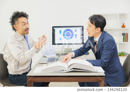 工程師們在辦公室一邊開會一邊查看文件。 136298120