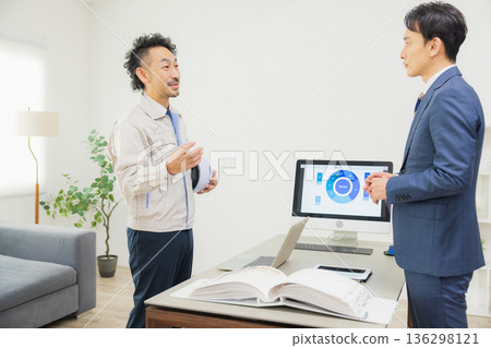 工程師們在辦公室一邊開會一邊查看文件。 工程師們在辦公室一邊開會一邊查看文件。 136298121