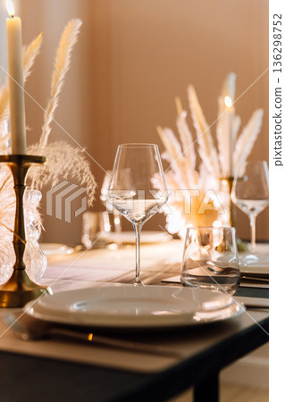 Candlelit elegant table setting with wine glass and pampas decor Candlelit elegant table setting with wine glass and pampas decor 136298752