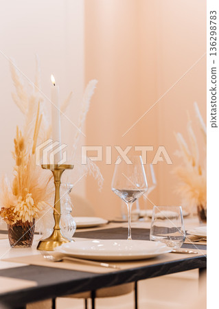 Elegant table setting with wine glass, candle and pampas decor on neutral background 136298783
