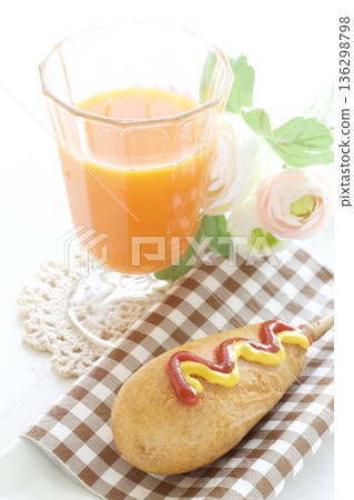 A snack of corn dogs and carrot juice A snack of corn dogs and carrot juice 136298798